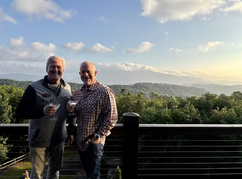 Angel Alvarez and Brad Weinbrum toasting on a mountain deck in Banner Elk, 2025